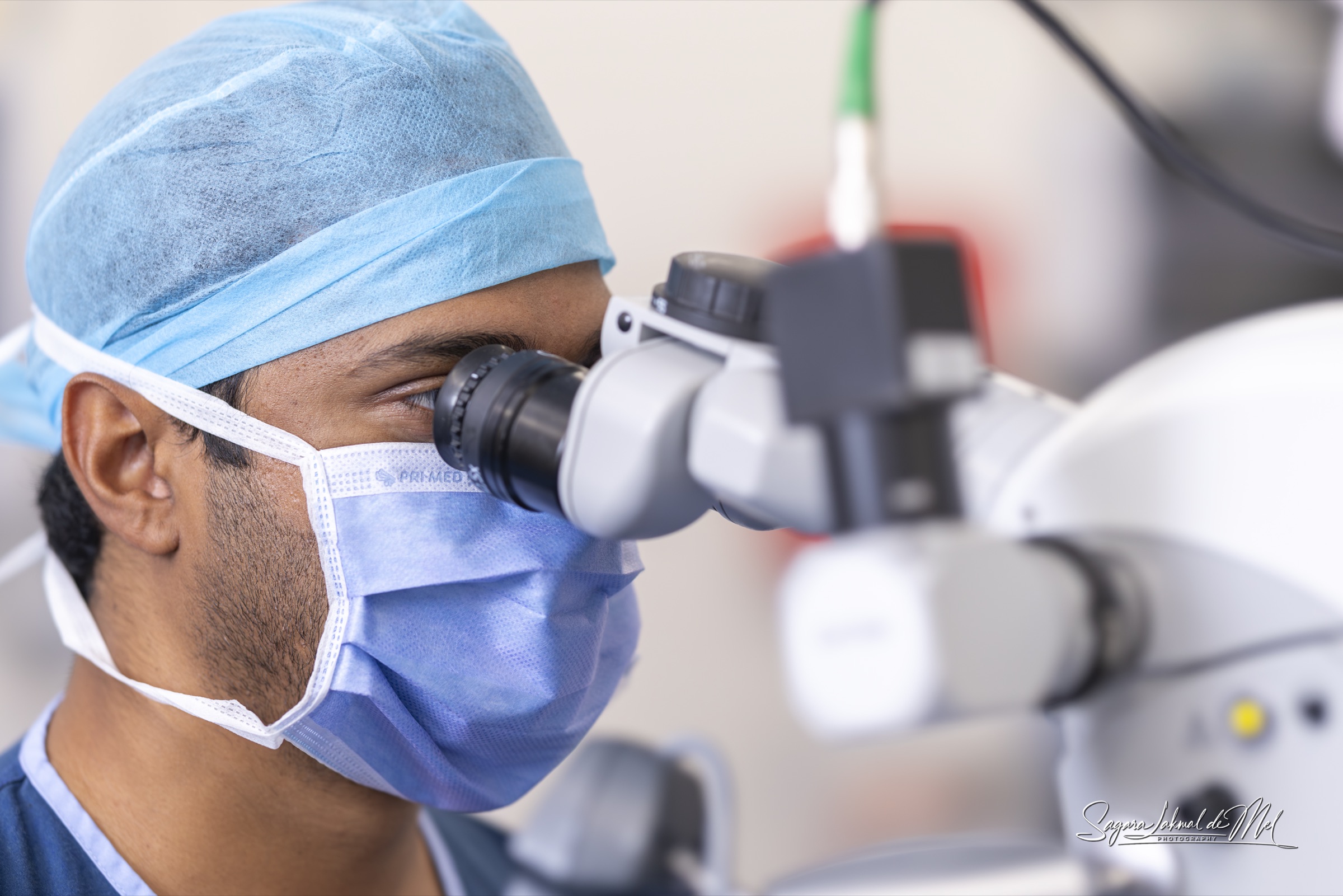 Dr. Gehan Karunaratne operating with a surgical microscope